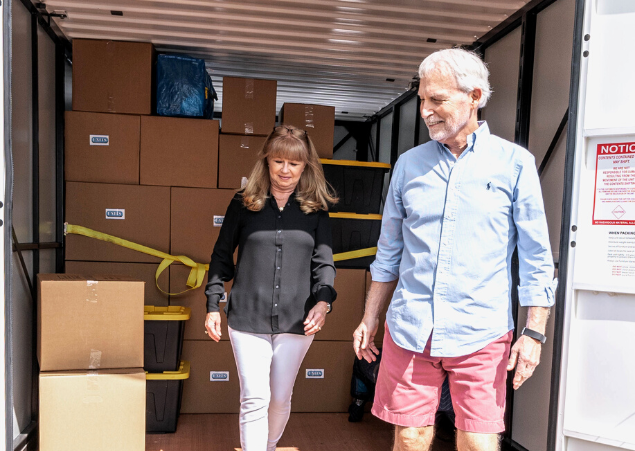 Man and woman walking out of their portable storage container after securing their belongings.