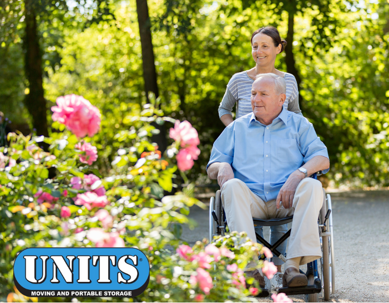 man in wheelchair in a garden senior living facililty