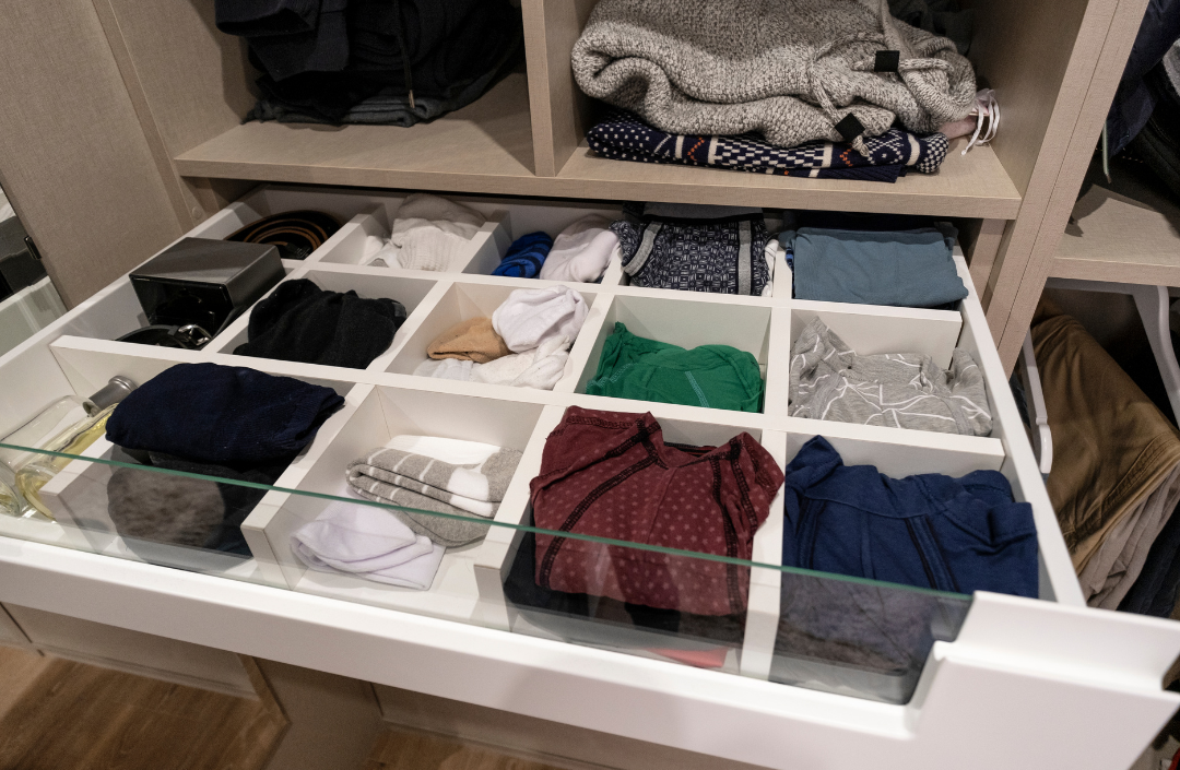 Clothes inside of a dresser that has been organized.