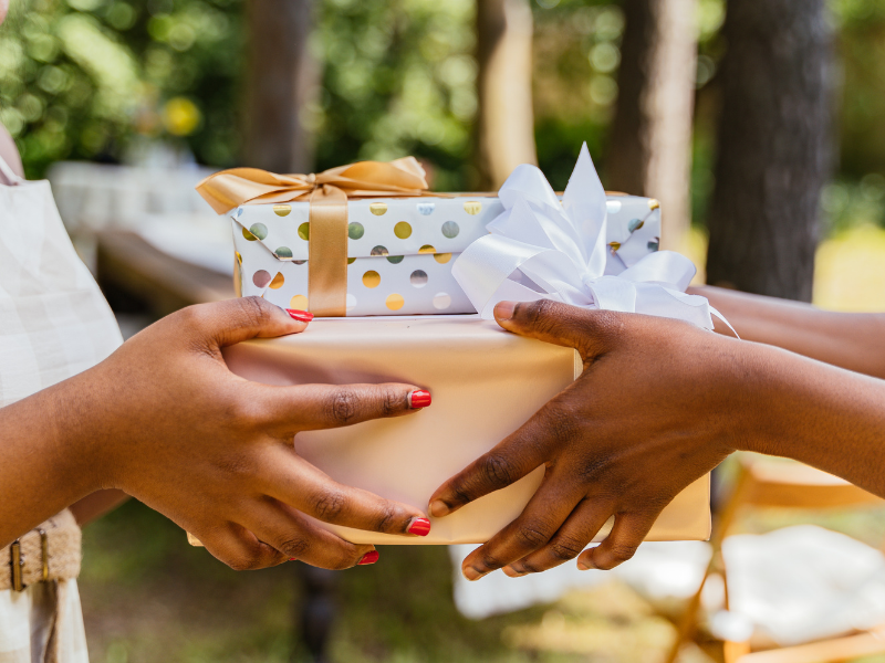 woman handing another woman Moving Gifts